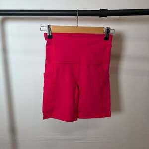 Fabletics PowerHold High-Waisted Short 7" with Pockets in Dark Pink XS